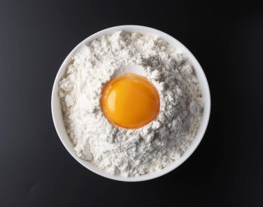 Siyah arka planda un ve yumurta sarısı.