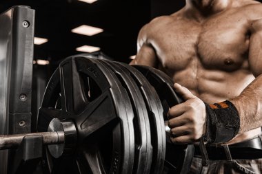 Güçlü atletik erkek bodybuilderl gövde gösteren kas spor salonunda