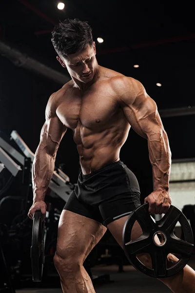 Sehr kraftvolle athletische Kerl Bodybuilder, führen Sie Übung mit dumm — Stockfoto