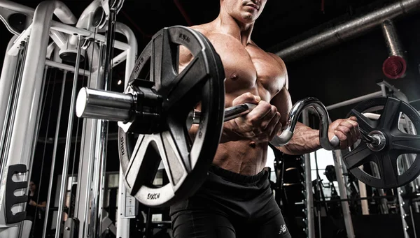 Culturista muscular atleta en el entrenamiento de gimnasia con barra —  Fotos de Stock