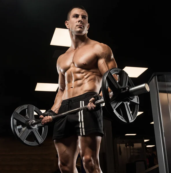 Hombre guapo con grandes músculos, posando en la cámara en el gimnasio — Foto de Stock