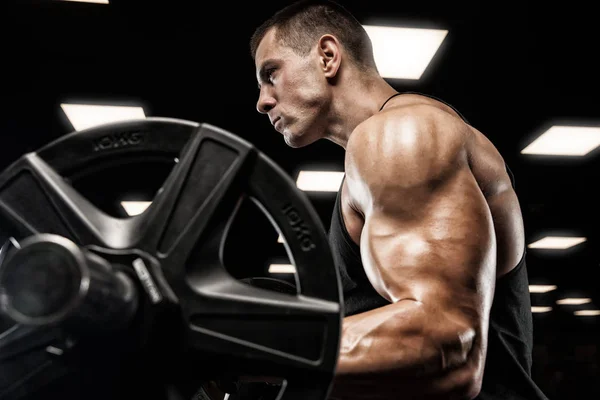 Bello uomo con grandi muscoli, in posa presso la fotocamera in palestra — Foto Stock