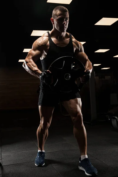 Schöner Mann mit großen Muskeln posiert in der Turnhalle vor der Kamera — Stockfoto