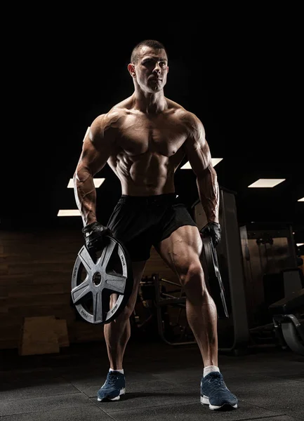 Handsome man with big muscles, posing at the camera in the gym — Stock Photo, Image