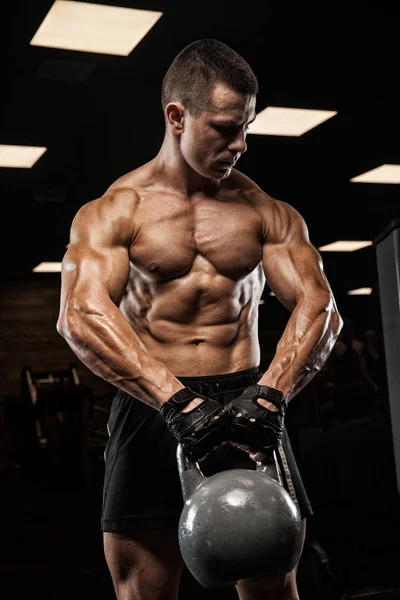 Bello uomo con grandi muscoli, in posa presso la fotocamera in palestra — Foto Stock