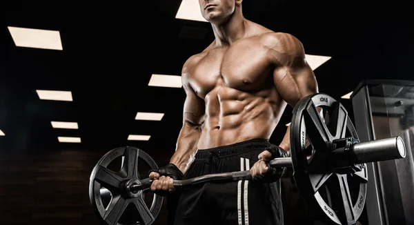 Hombre guapo con grandes músculos, posando en la cámara en el gimnasio —  Fotos de Stock