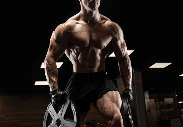 Hombre guapo con grandes músculos, posando en la cámara en el gimnasio — Foto de Stock