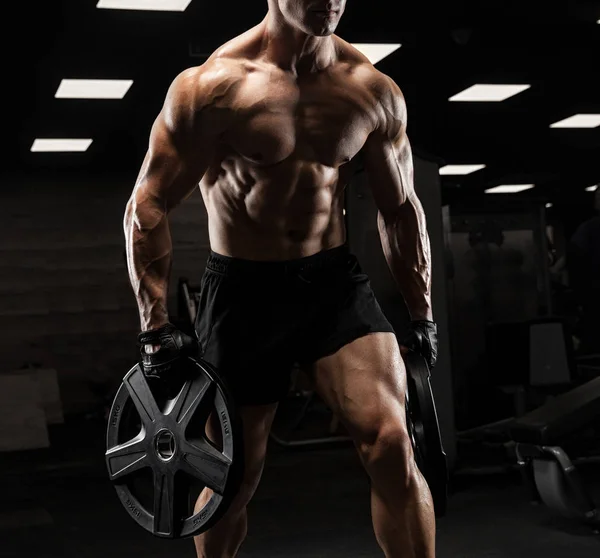 Hombre guapo con grandes músculos, posando en la cámara en el gimnasio —  Fotos de Stock