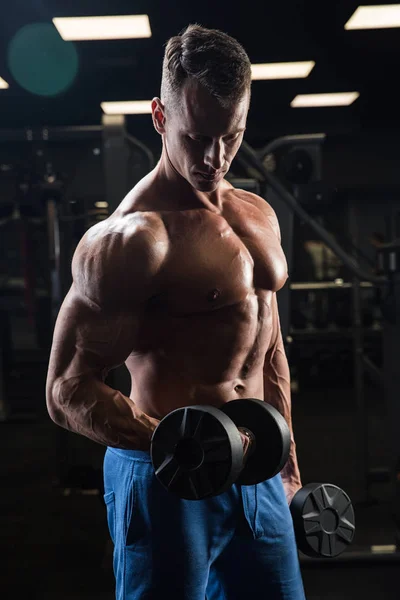 Hombre guapo con grandes músculos, posando en la cámara en el gimnasio — Foto de Stock