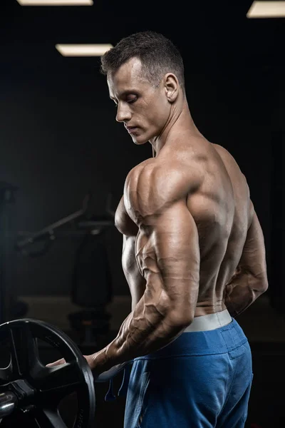 Knappe man met grote spieren, poseren bij de camera in de sportschool — Stockfoto