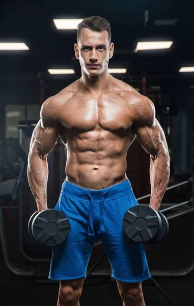 Hombre guapo con grandes músculos, posando en la cámara en el gimnasio —  Fotos de Stock