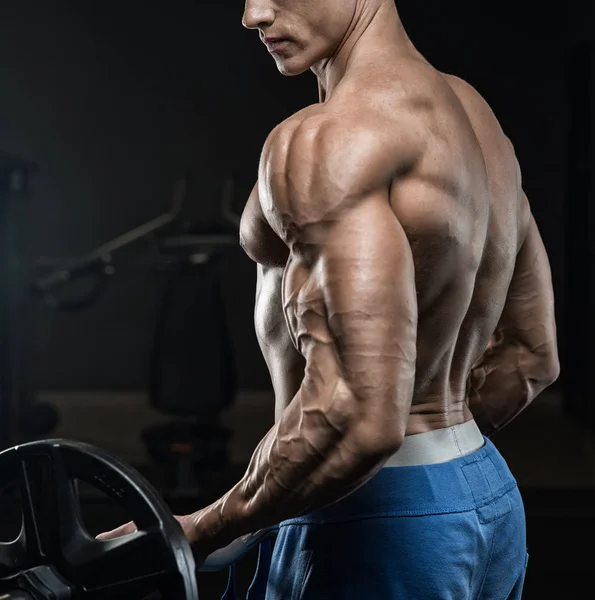 Przystojny mężczyzna z dużymi mięśniami, pozujący przed kamerą na siłowni — Zdjęcie stockowe