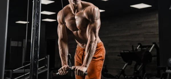 Bello uomo con grandi muscoli, in posa presso la fotocamera in palestra — Foto Stock