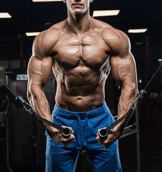 Bello uomo con grandi muscoli, in posa presso la fotocamera in palestra — Foto Stock