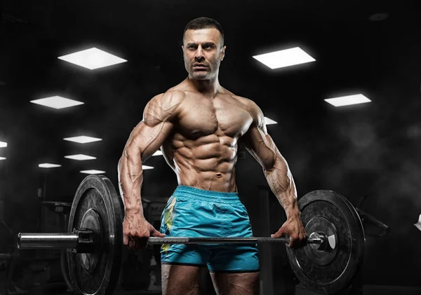 Hombre guapo con grandes músculos, posando en la cámara en el gimnasio — Foto de Stock