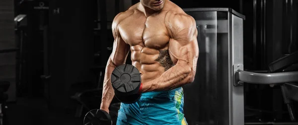 Красивий чоловік з великими м'язами, позує на камеру в спортзалі — стокове фото