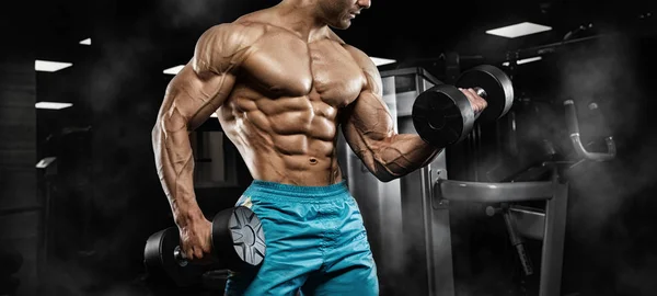 Hombre guapo con grandes músculos, posando en la cámara en el gimnasio —  Fotos de Stock