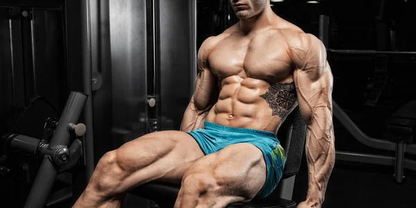 Stilig man med stora muskler, poserar vid kameran i gymmet — Stockfoto
