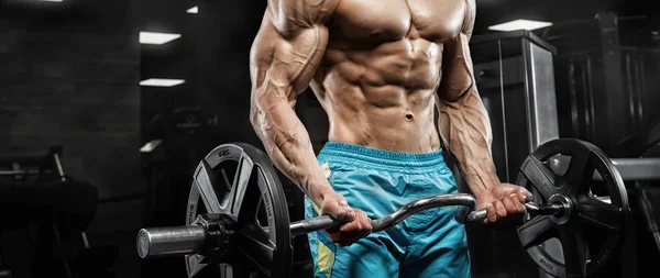 Hombre guapo con grandes músculos, posando en la cámara en el gimnasio —  Fotos de Stock