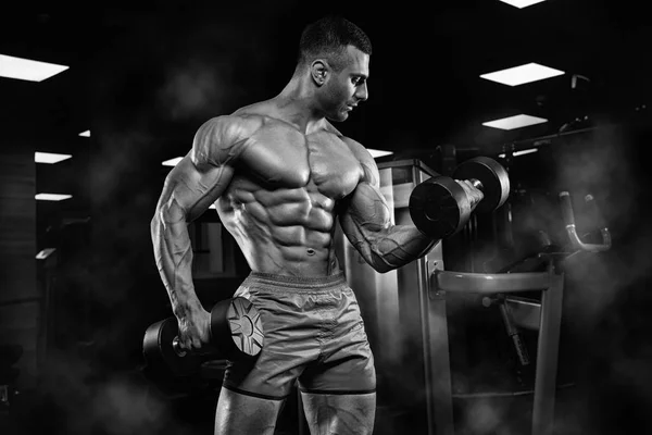 Hombre guapo con grandes músculos, posando en la cámara en el gimnasio —  Fotos de Stock