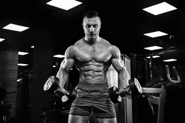 Hombre guapo con grandes músculos, posando en la cámara en el gimnasio —  Fotos de Stock