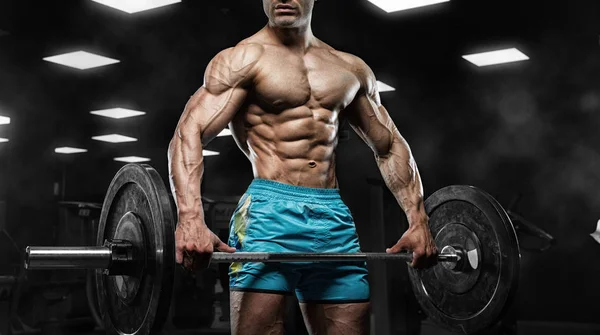 Красивый мужчина с большими мускулами, позирует перед камерой в спортзале — стоковое фото
