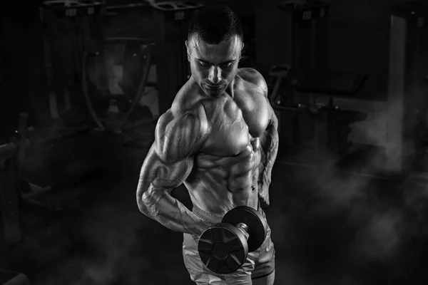 Hombre guapo con grandes músculos, posando en la cámara en el gimnasio — Foto de Stock