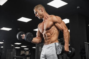 Elinde ağırlıkları olan genç bir adamın portresi.