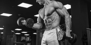 Elinde ağırlıkları olan genç bir adamın portresi.