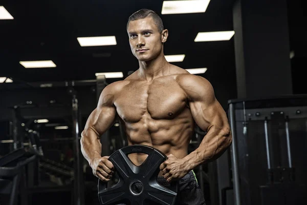 Portret van een fysiek jonge man met gewichten in de hand — Stockfoto