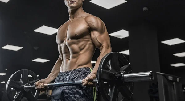 Porträt eines körperlich jungen Mannes, der Gewichte in der Hand hält — Stockfoto