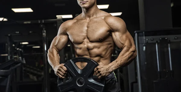Porträt eines körperlich jungen Mannes, der Gewichte in der Hand hält — Stockfoto