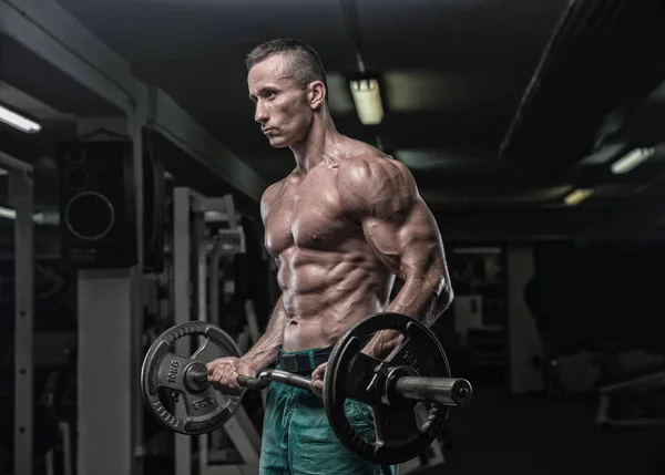 Knappe man met grote spieren, poseren bij de camera in de sportschool — Stockfoto