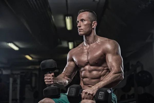 Hombre guapo con grandes músculos, posando en la cámara en el gimnasio — Foto de Stock