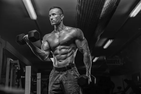 Hombre guapo con grandes músculos, posando en la cámara en el gimnasio — Foto de Stock