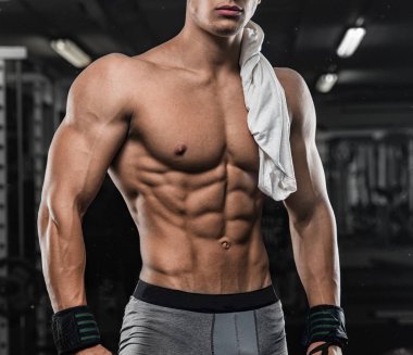 güçlü ve yakışıklı bir genç adam dumbbells ile egzersiz yaparak