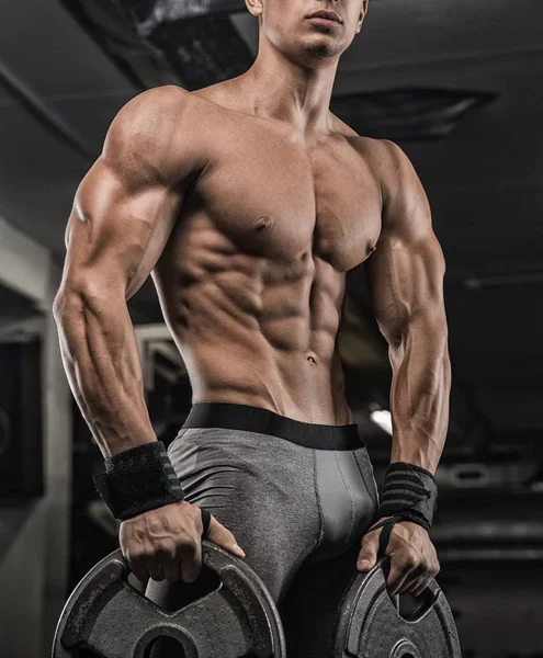 Hombre guapo con grandes músculos, posando en la cámara en el gimnasio —  Fotos de Stock