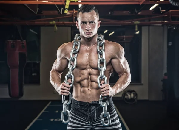 Pria tampan dengan otot besar, berpose di kamera di gym — Stok Foto