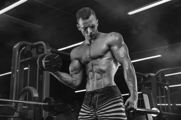 Bodybuilder trainiert mit Hanteln im Fitnessstudio — Stockfoto