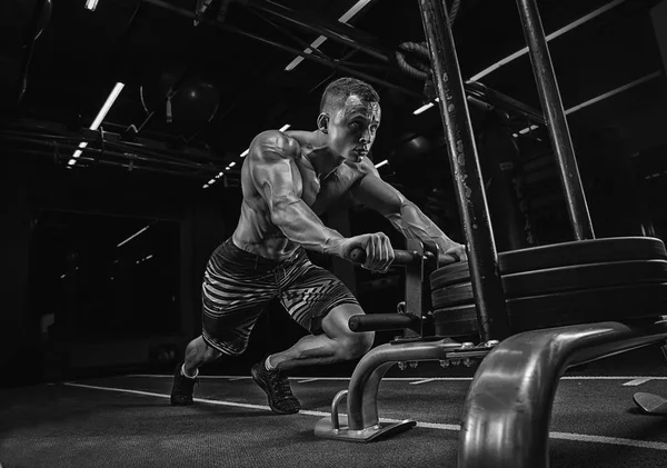 Фітнес санки штовхає чоловіка штовхаючи ваги тренування вправи — стокове фото