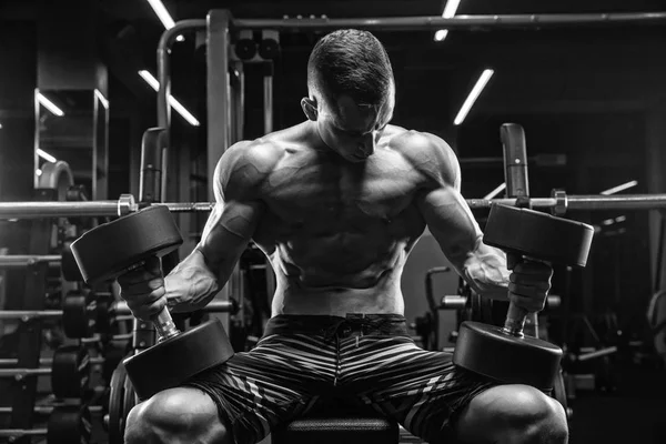 Hombre guapo con grandes músculos, posando en la cámara en el gimnasio — Foto de Stock