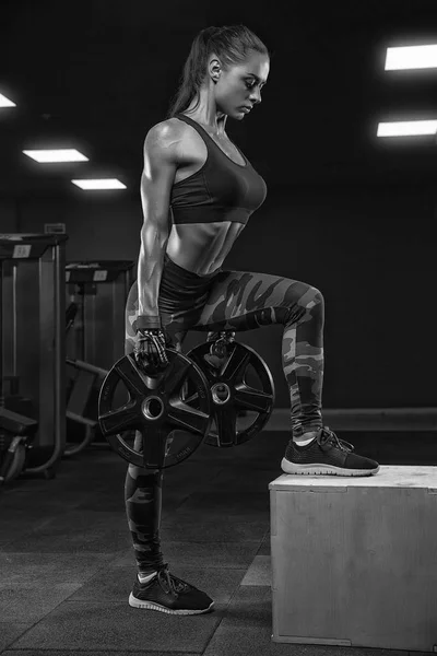 Mujer deportiva haciendo sentadillas con una barra en el gimnasio —  Fotos de Stock