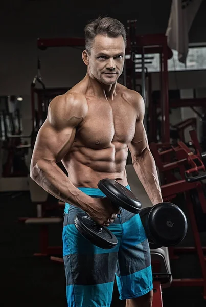 Brutális erős sportos férfi szivattyúzás fel izmok edzés bodybuildi — Stock Fotó