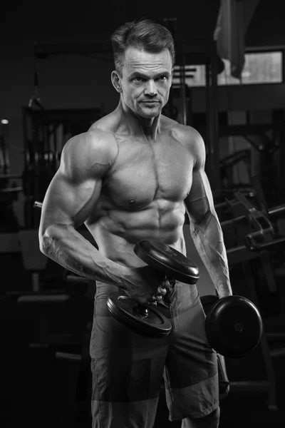Zeer energie-atletische man bodybuilder, uitvoeren van de oefening met stom — Stockfoto