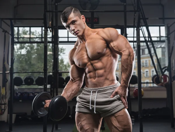 Modelo de fitness Hombre posando en el gimnasio. Hombre guapo con grandes  músculos, posando en la cámara en el gimnasio Fotografía de stock - Alamy