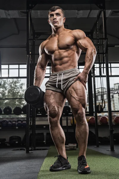 Attrayant grand bodybuilder musculaire faisant des haltères lourds en mo — Photo