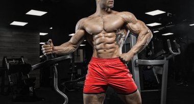 adam içinde jimnastik salonu. Kaslı vücut geliştirmeci adam karakeçi ile yapıyor