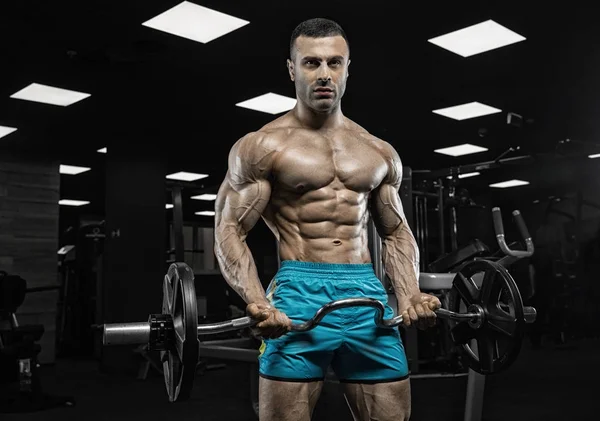 Bodybuilder met bumbbells gewichten op de sportschool uit te werken — Stockfoto