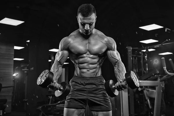 Hombre en el gimnasio. Musculoso culturista chico haciendo ejercicios con barbo —  Fotos de Stock