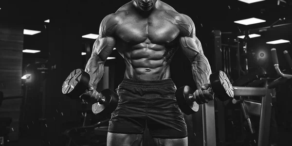 Hombre en el gimnasio. Musculoso culturista chico haciendo ejercicios con barbo — Foto de Stock